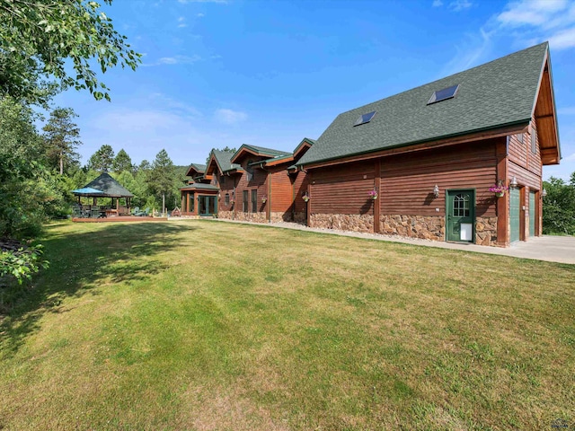 view of yard featuring a garage, a patio area, and a gazebo