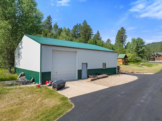 view of outdoor structure with a garage and a lawn