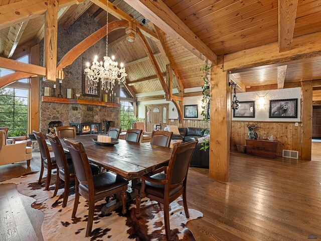 dining space with an inviting chandelier, a fireplace, hardwood / wood-style floors, and wood ceiling