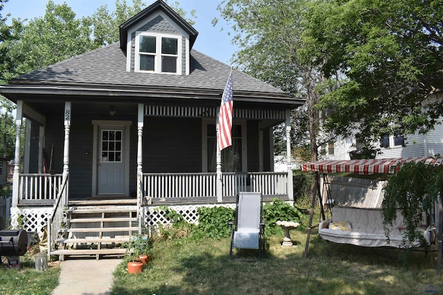 view of front of home with covered porch and a front lawn