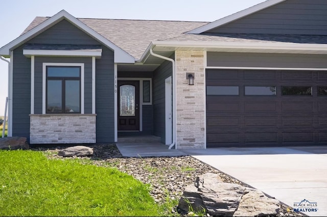 view of front of home with a garage, stone siding, and roof with shingles