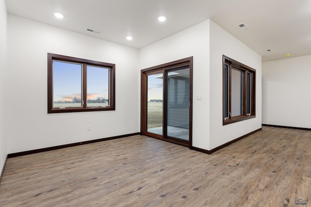 unfurnished room featuring light wood-type flooring, baseboards, visible vents, and recessed lighting