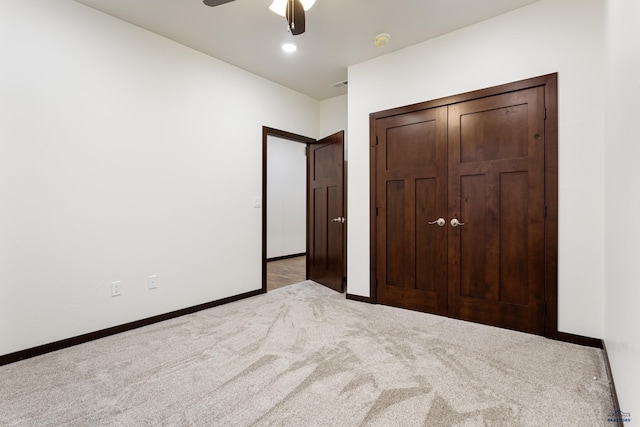 unfurnished bedroom featuring ceiling fan, recessed lighting, light colored carpet, baseboards, and a closet