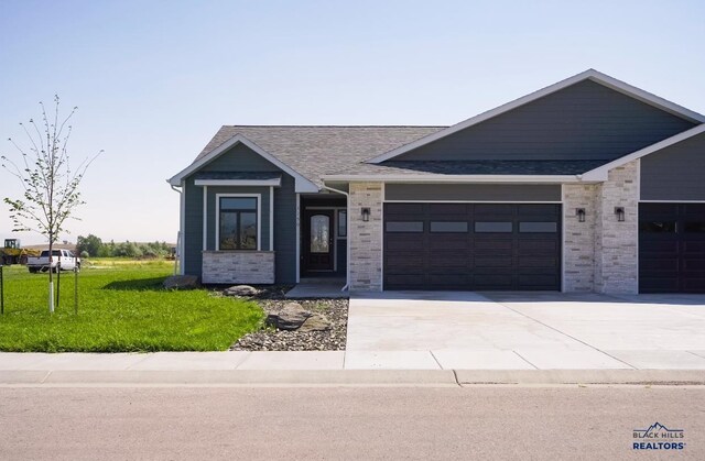 view of front of house featuring an attached garage, driveway, and a front lawn