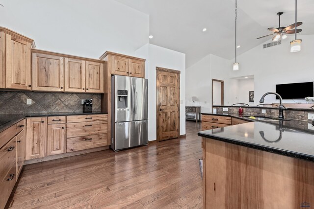 kitchen featuring ceiling fan, decorative backsplash, stainless steel fridge with ice dispenser, and dark wood-type flooring