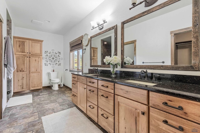 bathroom featuring tile patterned flooring, double sink vanity, and toilet