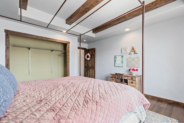 bedroom with beamed ceiling, a closet, and hardwood / wood-style floors