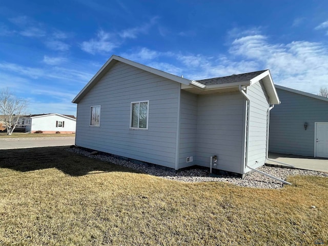 view of side of home with a yard