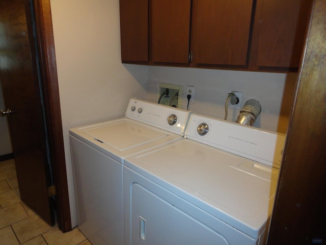 laundry room featuring cabinets, light tile patterned floors, and separate washer and dryer