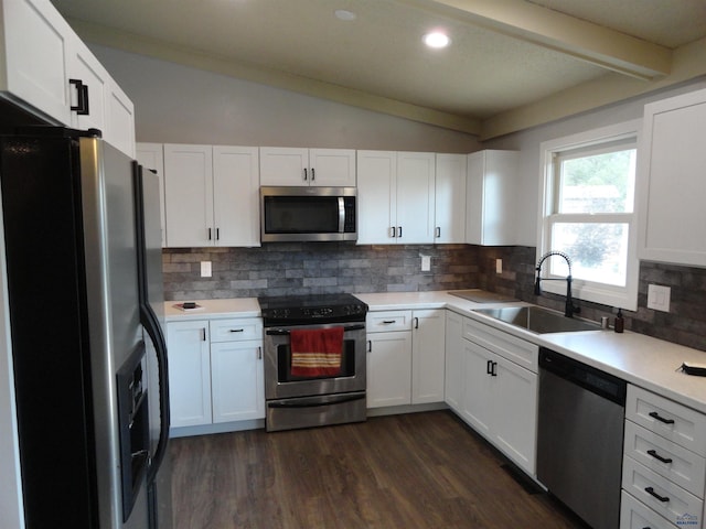 kitchen featuring decorative backsplash, stainless steel appliances, sink, lofted ceiling with beams, and white cabinets