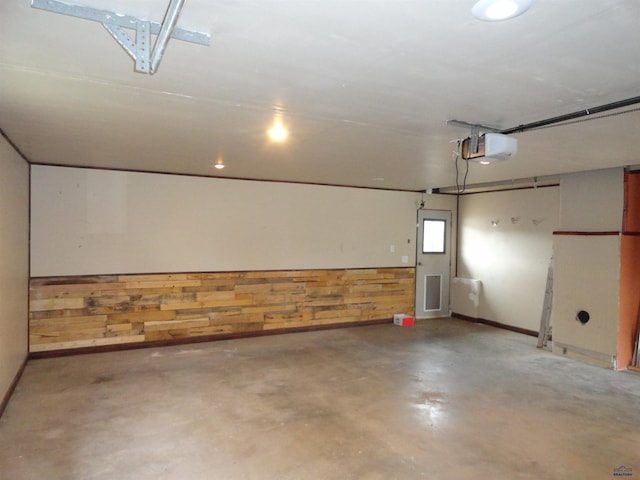 garage with a garage door opener and wooden walls