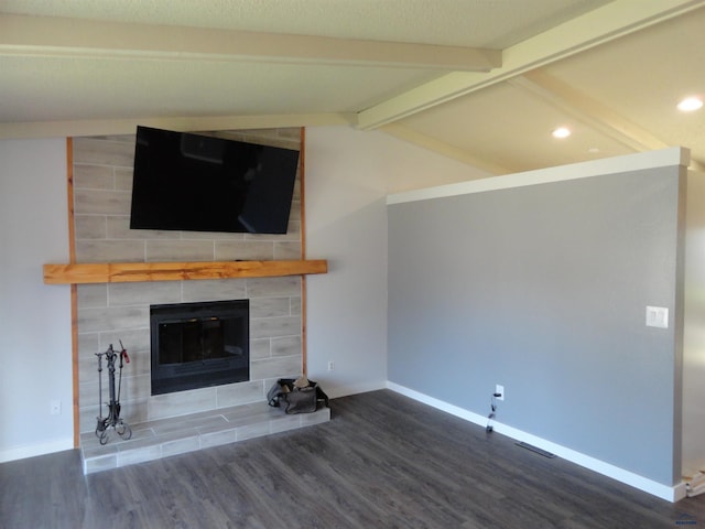 unfurnished living room with a fireplace, wood-type flooring, and lofted ceiling with beams