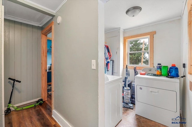 laundry area with dark wood-type flooring, ornamental molding, and washing machine and clothes dryer