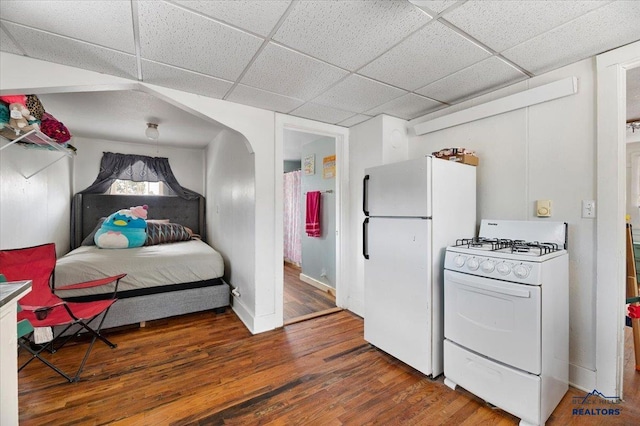 interior space featuring white appliances, a paneled ceiling, and hardwood / wood-style flooring