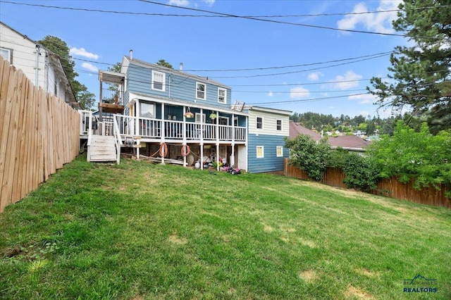 rear view of house with a deck and a yard