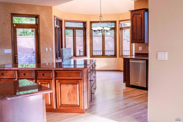 kitchen featuring pendant lighting, stainless steel dishwasher, light hardwood / wood-style flooring, and a chandelier