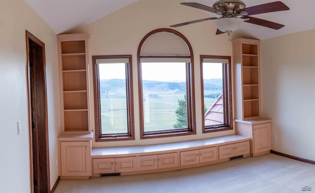 interior space featuring a wealth of natural light, ceiling fan, and light colored carpet