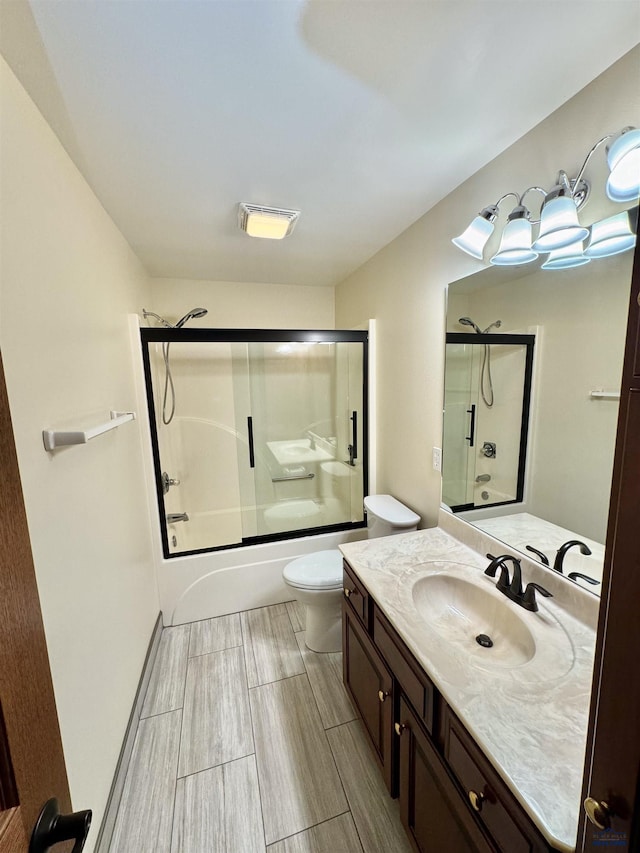 full bathroom featuring tile patterned floors, vanity, bath / shower combo with glass door, and toilet