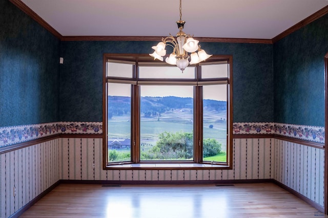 spare room featuring hardwood / wood-style floors, ornamental molding, and a healthy amount of sunlight