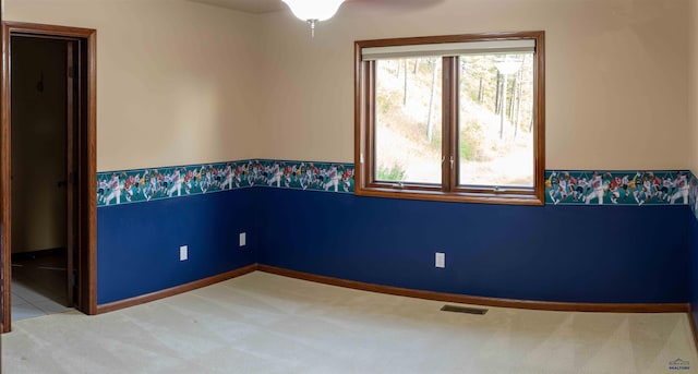 carpeted spare room with ceiling fan and a healthy amount of sunlight