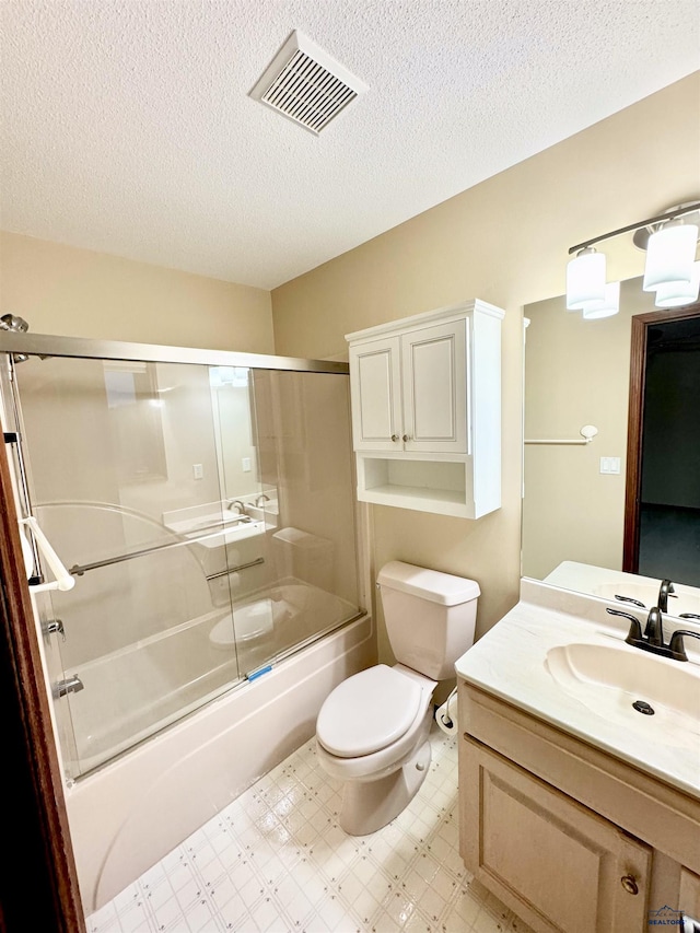 full bathroom featuring a textured ceiling, tile patterned flooring, shower / bath combination with glass door, vanity, and toilet