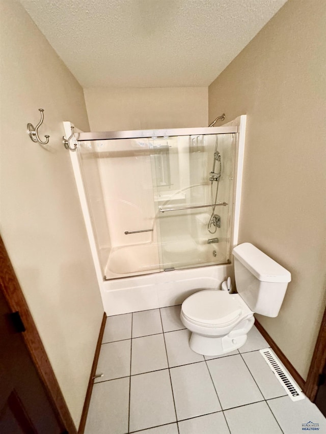 bathroom featuring tile patterned flooring, toilet, a textured ceiling, and shower / bath combination with glass door