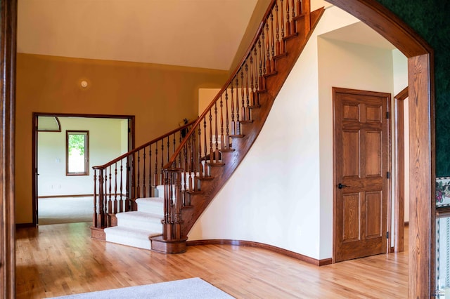 stairway featuring hardwood / wood-style flooring and a high ceiling