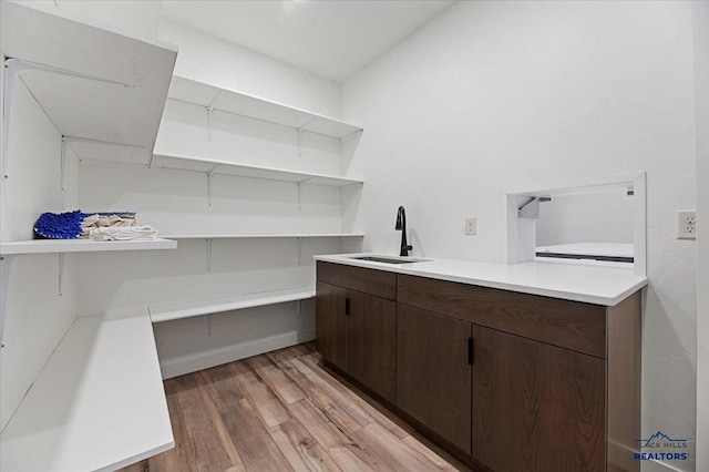 laundry area featuring a sink and light wood-style floors