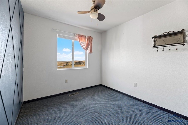 carpeted empty room with visible vents, baseboards, and a ceiling fan