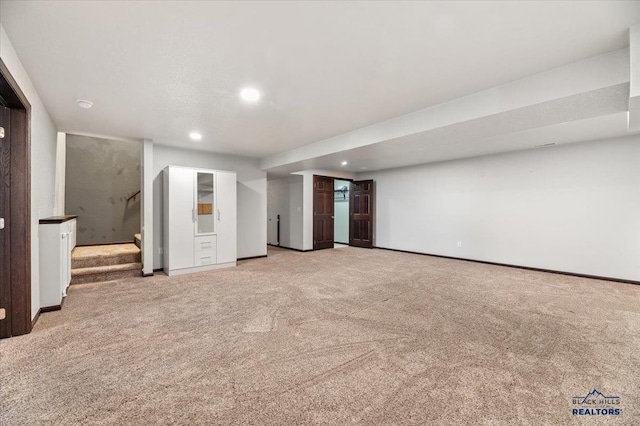 unfurnished room featuring recessed lighting, light carpet, stairway, and baseboards