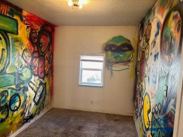 carpeted empty room featuring a textured ceiling