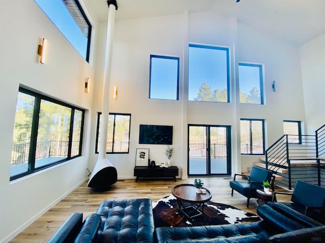 living room featuring high vaulted ceiling and light hardwood / wood-style flooring