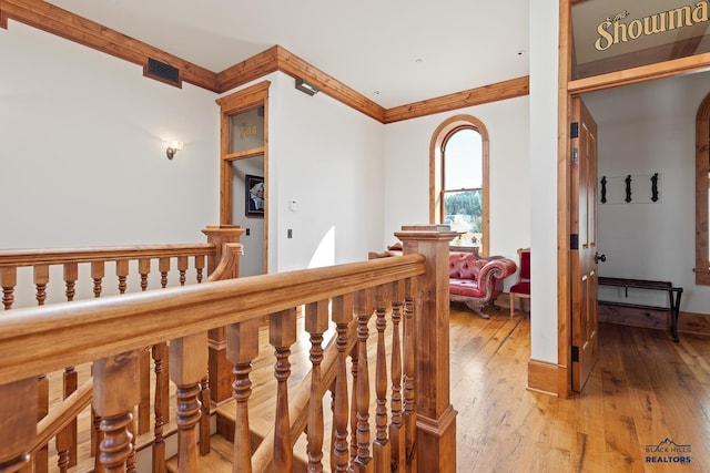 corridor with hardwood / wood-style flooring and crown molding