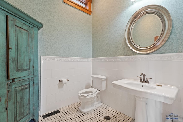 619 Mt Rushmore Rd, Custer, SD 57730 - bathroom featuring a wainscoted wall, wallpapered walls, and tile walls