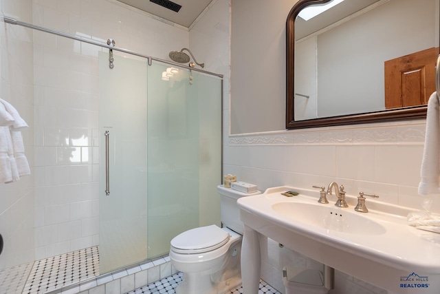 bathroom featuring backsplash, toilet, tile patterned flooring, an enclosed shower, and tile walls