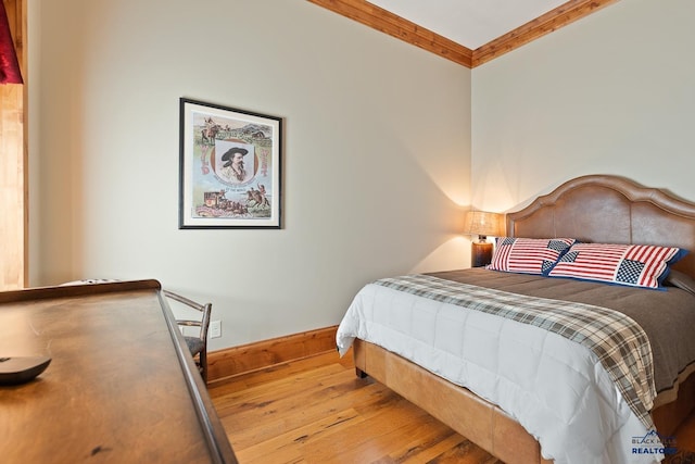 bedroom featuring light hardwood / wood-style flooring and ornamental molding