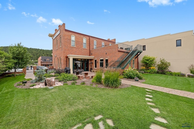 rear view of property featuring a patio area and a lawn