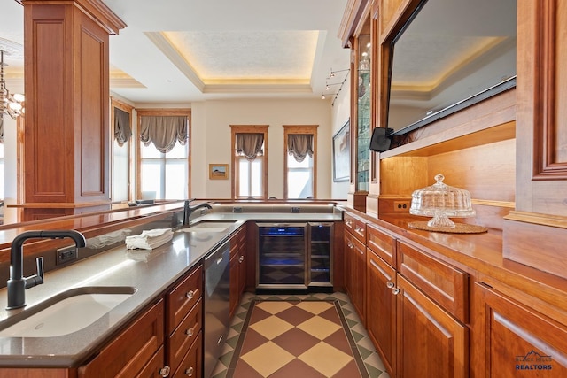 kitchen featuring sink, a raised ceiling, stainless steel dishwasher, and beverage cooler