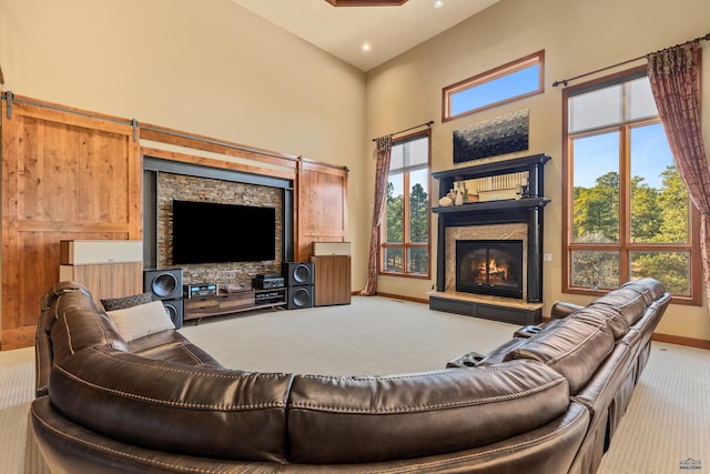 carpeted living room featuring a fireplace, a healthy amount of sunlight, and a towering ceiling