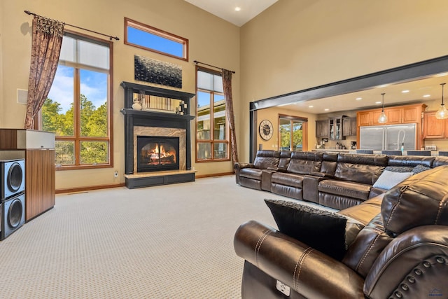 living room with a towering ceiling and light carpet