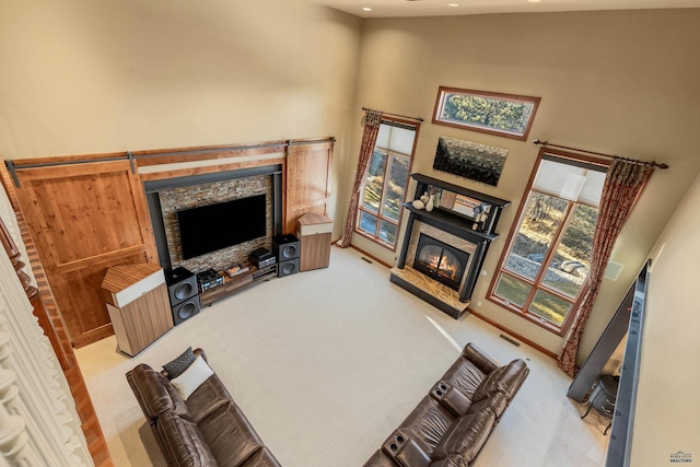 living room with a towering ceiling and light carpet