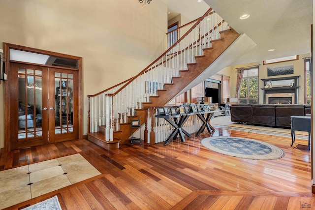 interior space with a high ceiling, wood-type flooring, and french doors