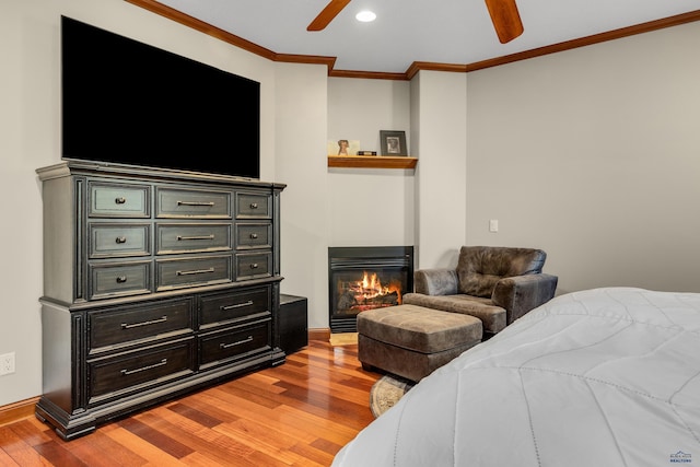 bedroom with ceiling fan, ornamental molding, and light wood-type flooring