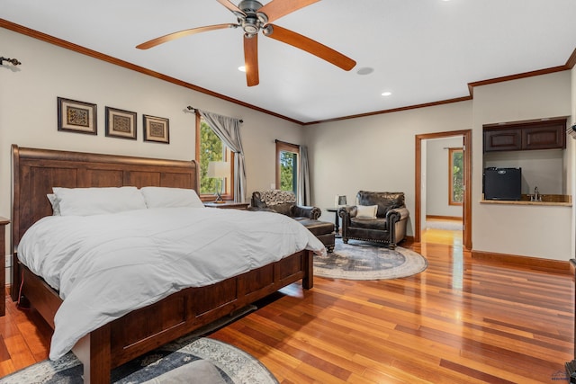 bedroom with light hardwood / wood-style floors, crown molding, ceiling fan, and black fridge