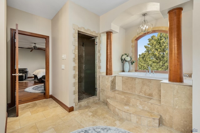 bathroom featuring ceiling fan with notable chandelier, shower with separate bathtub, decorative columns, and wood-type flooring