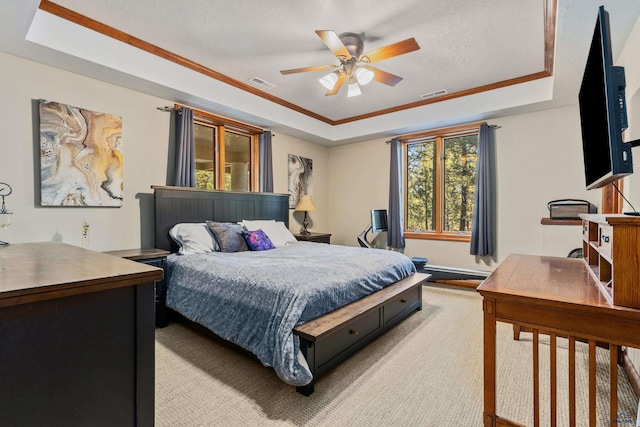 bedroom featuring ceiling fan, a textured ceiling, light carpet, and a tray ceiling