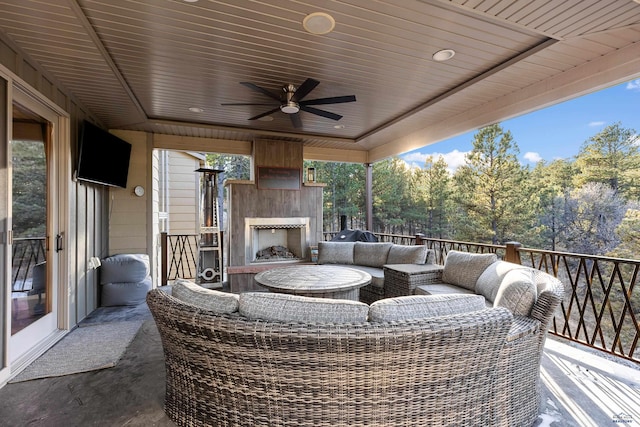 exterior space featuring ceiling fan and an outdoor living space with a fireplace