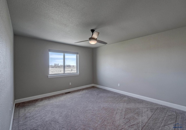 empty room featuring ceiling fan, a textured ceiling, and carpet flooring