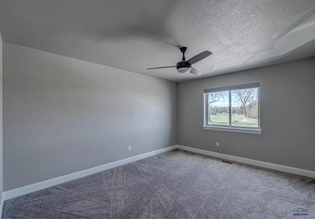 carpeted spare room featuring a textured ceiling and ceiling fan