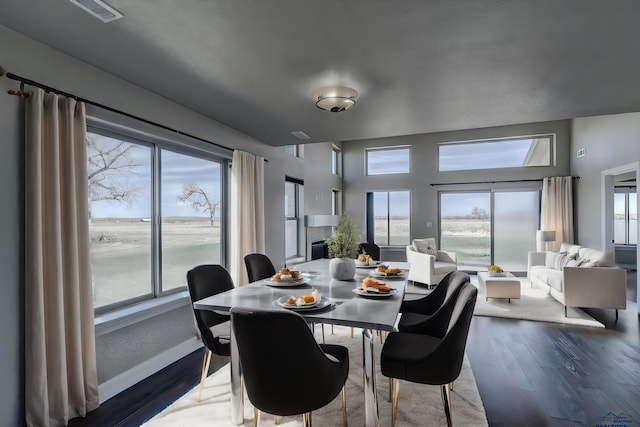 dining space with hardwood / wood-style floors and a water view